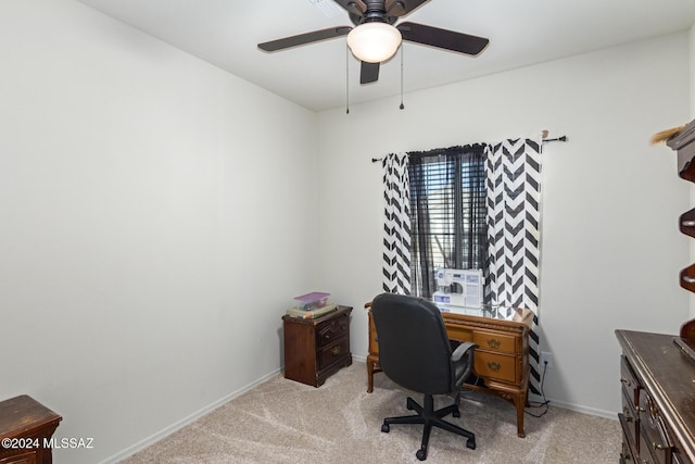 home office with a ceiling fan, light colored carpet, and baseboards