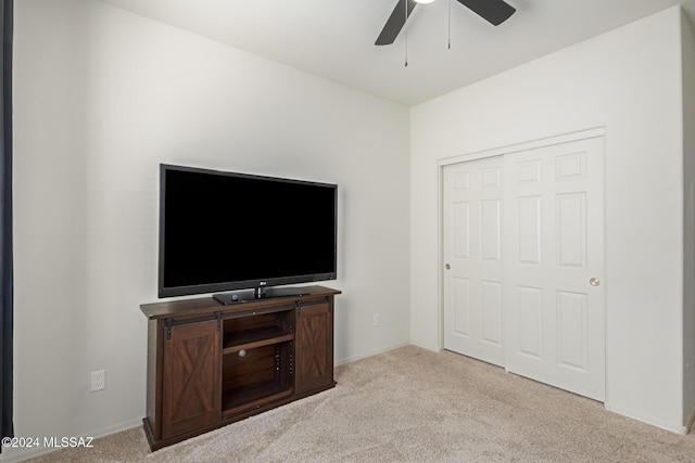 unfurnished living room featuring baseboards, ceiling fan, and carpet