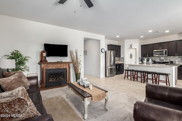 living room featuring recessed lighting, light tile patterned flooring, ceiling fan, a glass covered fireplace, and visible vents