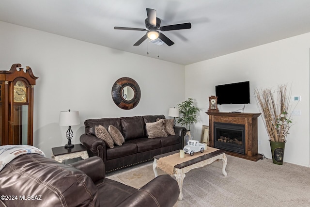 living room featuring ceiling fan, carpet floors, and a glass covered fireplace