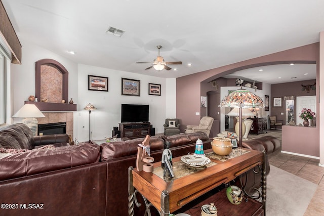 60621 E Eagle Heights Dr, Tucson, AZ 85739 - living room featuring arched walkways, tile patterned floors, a ceiling fan, a tile fireplace, and visible vents