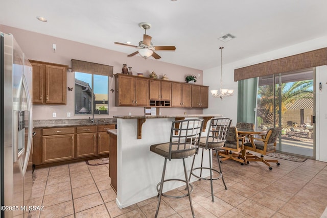 60621 E Eagle Heights Dr, Tucson, AZ 85739 - kitchen featuring stainless steel fridge, brown cabinets, and visible vents