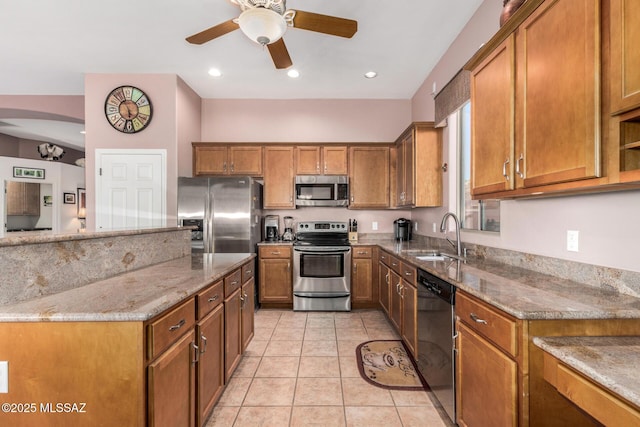 60621 E Eagle Heights Dr, Tucson, AZ 85739 - kitchen featuring ceiling fan, light stone countertops, brown cabinets, a sink, and stainless steel appliances