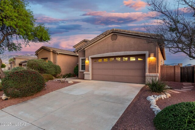 60621 E Eagle Heights Dr, Tucson, AZ 85739 - mediterranean / spanish home featuring a garage, stucco siding, driveway, and a tiled roof