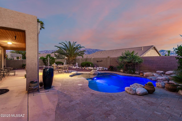 60621 E Eagle Heights Dr, Tucson, AZ 85739 - pool at dusk with a fenced in pool, outdoor dining area, a fenced backyard, and a patio area