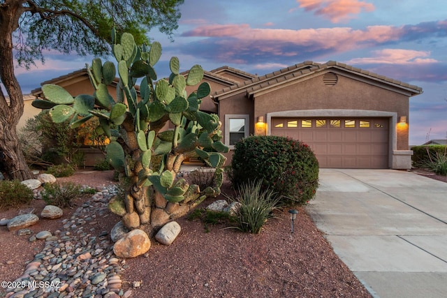 60621 E Eagle Heights Dr, Tucson, AZ 85739 - mediterranean / spanish home featuring a garage, stucco siding, driveway, and a tiled roof