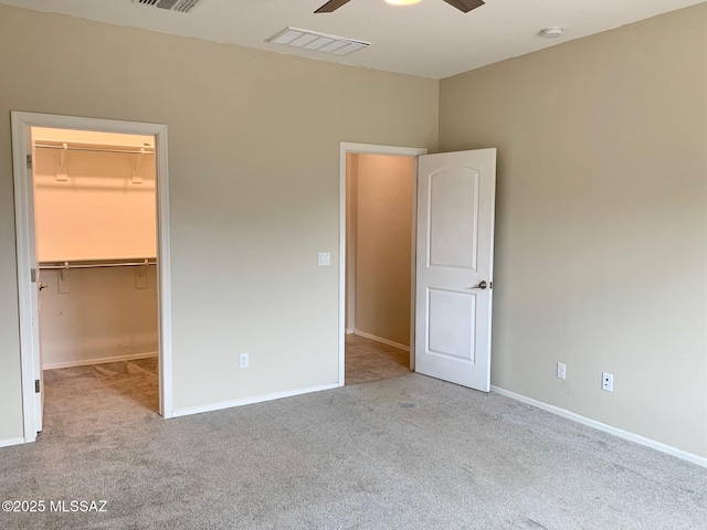 unfurnished bedroom featuring carpet flooring, visible vents, and a spacious closet