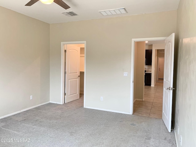unfurnished bedroom with visible vents, light colored carpet, and baseboards
