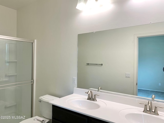 bathroom with a shower, toilet, double vanity, and a sink