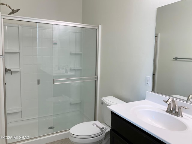 bathroom with vanity, toilet, and a shower stall