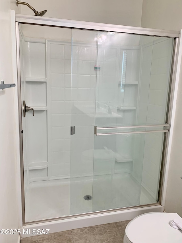 bathroom with toilet, a shower stall, and tile patterned floors