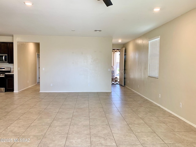 empty room featuring light tile patterned floors, recessed lighting, and baseboards
