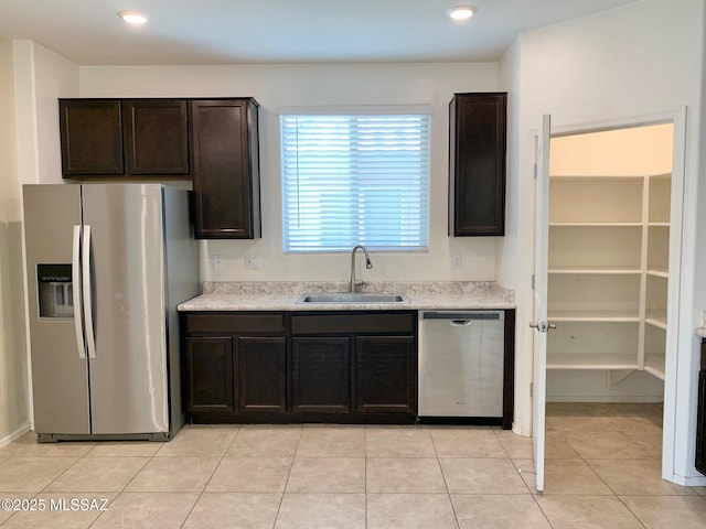 kitchen featuring dark brown cabinets, appliances with stainless steel finishes, light countertops, and a sink