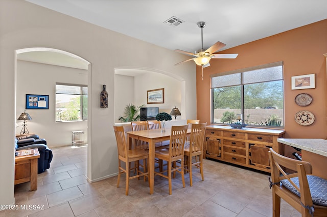 dining room featuring a wealth of natural light, light tile patterned flooring, ceiling fan, and visible vents