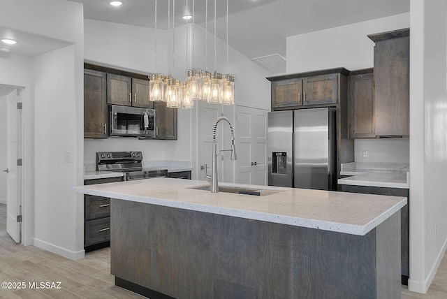 172 Vereda Cabrilla Ln, Rio Rico, AZ 85648 - kitchen with appliances with stainless steel finishes, a sink, light wood-style floors, and dark brown cabinetry