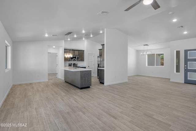 172 Vereda Cabrilla Ln, Rio Rico, AZ 85648 - kitchen with stainless steel microwave, ceiling fan with notable chandelier, open floor plan, and light countertops
