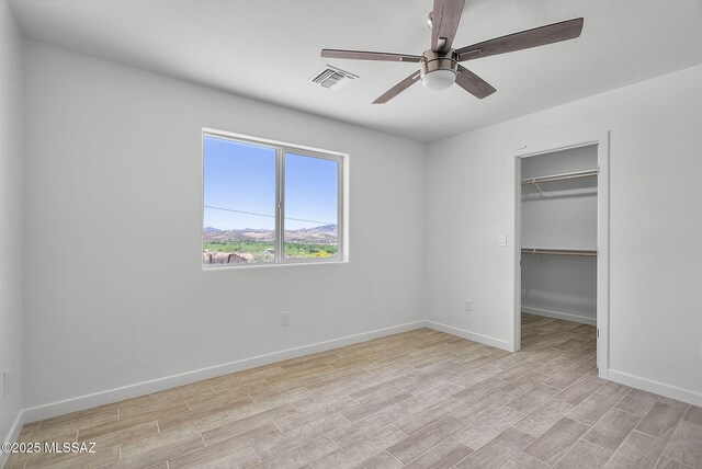 172 Vereda Cabrilla Ln, Rio Rico, AZ 85648 - unfurnished bedroom featuring visible vents, light wood-type flooring, baseboards, and a walk in closet