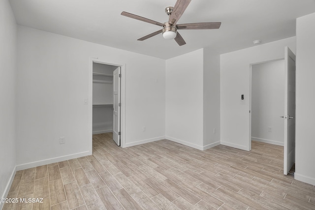 172 Vereda Cabrilla Ln, Rio Rico, AZ 85648 - unfurnished bedroom featuring a ceiling fan, a walk in closet, baseboards, and light wood-type flooring