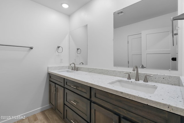 172 Vereda Cabrilla Ln, Rio Rico, AZ 85648 - bathroom featuring double vanity, wood finished floors, baseboards, and a sink