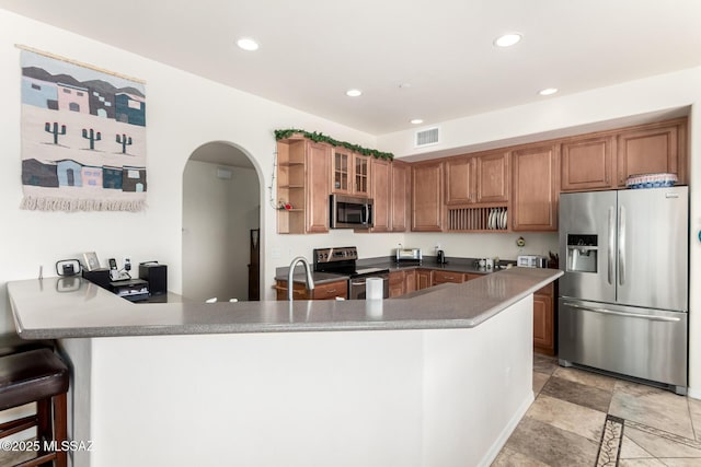 5498 N Desert Wood Pl, Tucson, AZ 85745 - kitchen with open shelves, arched walkways, stainless steel appliances, a peninsula, and visible vents