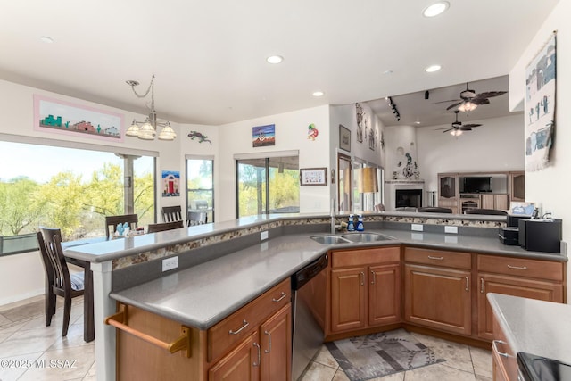 5498 N Desert Wood Pl, Tucson, AZ 85745 - kitchen with stainless steel dishwasher, brown cabinets, recessed lighting, and ceiling fan with notable chandelier