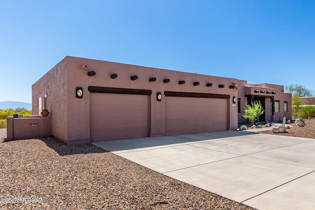 5498 N Desert Wood Pl, Tucson, AZ 85745 - pueblo-style house featuring concrete driveway, a garage, and stucco siding