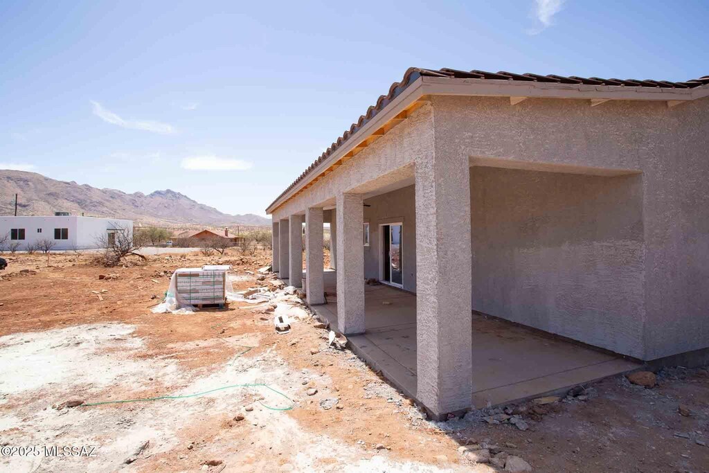1849 Burns Ct, Rio Rico, AZ 85648 - view of side of home with a tile roof, a mountain view, stucco siding, and a patio area