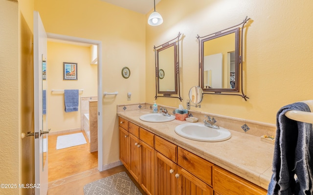 full bath featuring a sink, tile patterned floors, a bathing tub, and double vanity