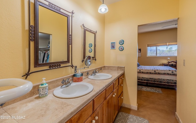 full bath with a sink, ensuite bath, and double vanity