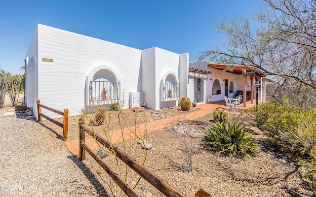 view of front of home with a patio and stucco siding