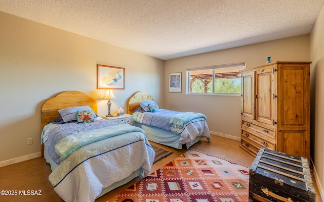 carpeted bedroom with a textured ceiling and baseboards