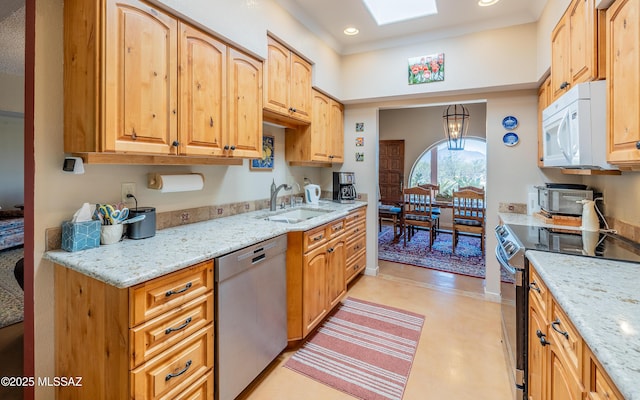 kitchen with appliances with stainless steel finishes, light stone countertops, a sink, a toaster, and recessed lighting