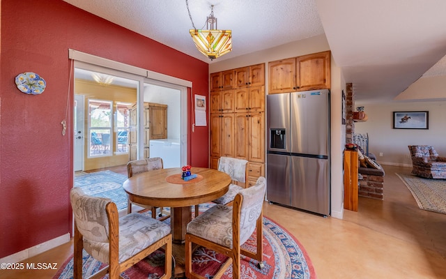 dining area with baseboards, a textured wall, a textured ceiling, and washer / clothes dryer