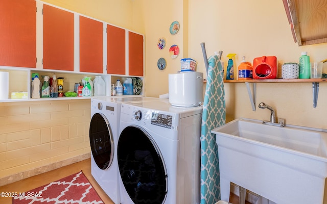 laundry room with washer and dryer and a sink
