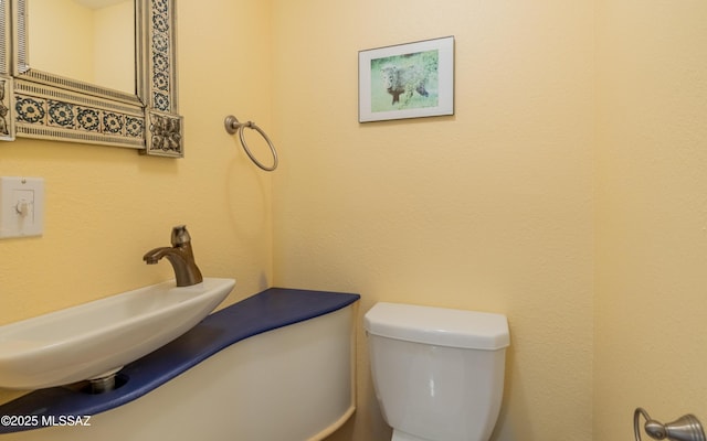 half bath featuring a sink and toilet