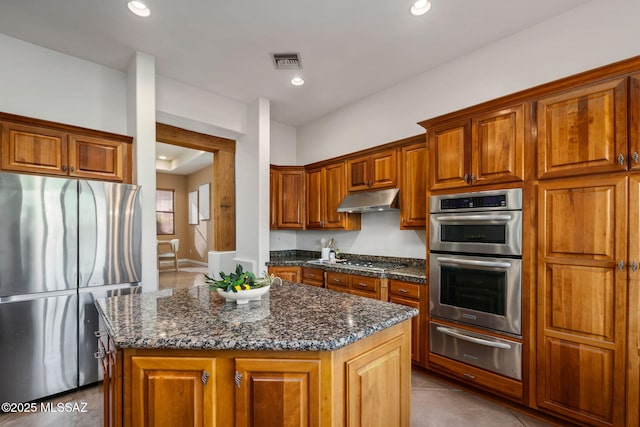 6340 N Placita Alta Reposa, Tucson, AZ 85750 - kitchen featuring stainless steel appliances, a warming drawer, brown cabinetry, and under cabinet range hood