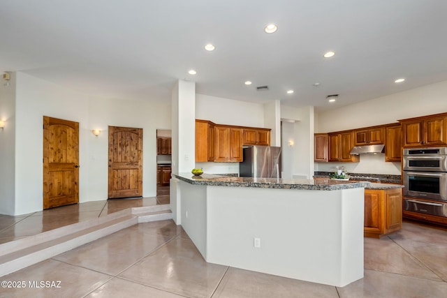 6340 N Placita Alta Reposa, Tucson, AZ 85750 - kitchen featuring appliances with stainless steel finishes, under cabinet range hood, recessed lighting, a warming drawer, and brown cabinetry
