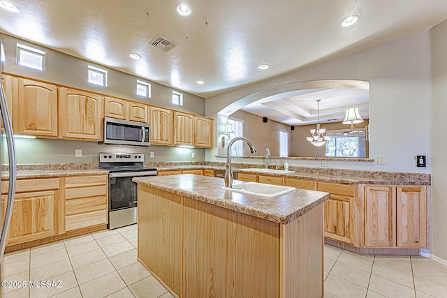 kitchen with stainless steel appliances, light brown cabinets, visible vents, light countertops, and arched walkways