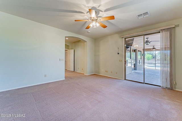 unfurnished room featuring visible vents, ceiling fan, arched walkways, carpet floors, and baseboards