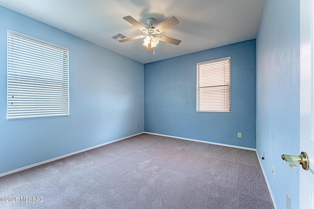 carpeted empty room featuring visible vents, ceiling fan, and baseboards
