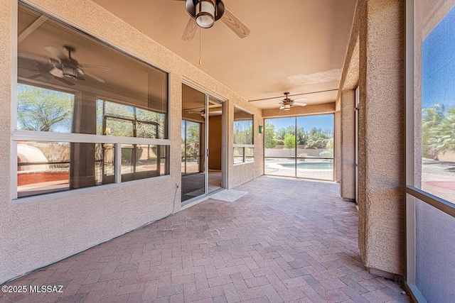 unfurnished sunroom with a ceiling fan