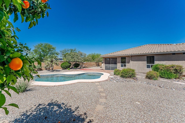 view of swimming pool with a fenced in pool, a fenced backyard, a patio area, and a sunroom