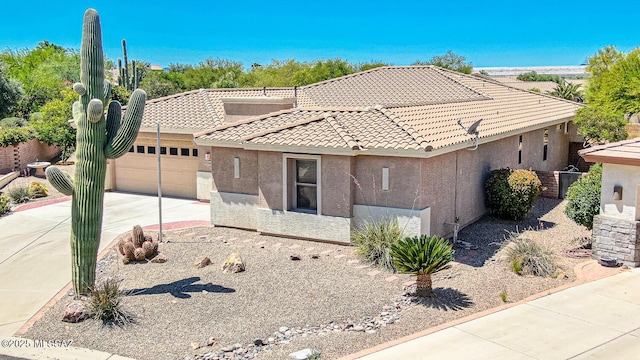 view of front of property featuring driveway, stucco siding, an attached garage, and a tile roof