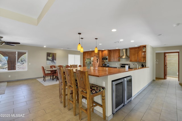 kitchen with wall chimney range hood, open shelves, beverage cooler, recessed lighting, and stainless steel appliances