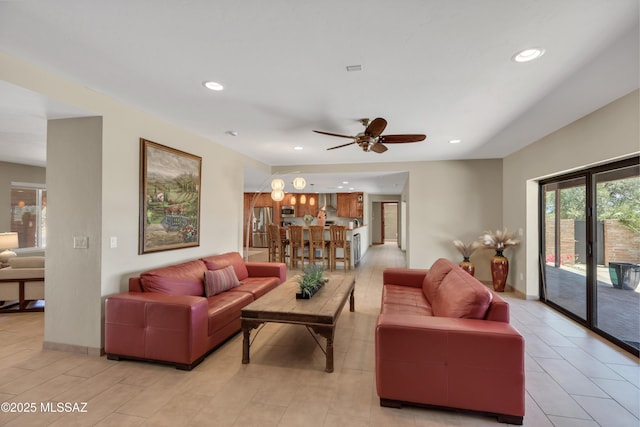 living area with baseboards, ceiling fan, and recessed lighting