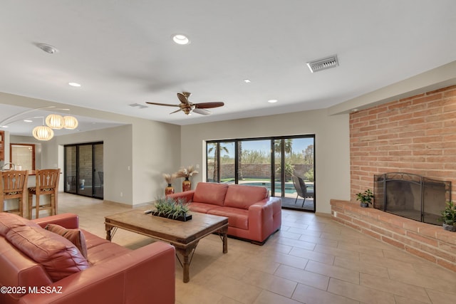 living area featuring light tile patterned flooring, recessed lighting, and a fireplace