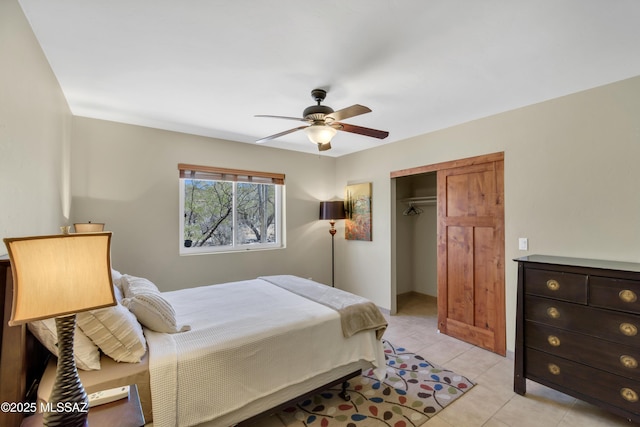 bedroom with a ceiling fan, light tile patterned floors, and a closet