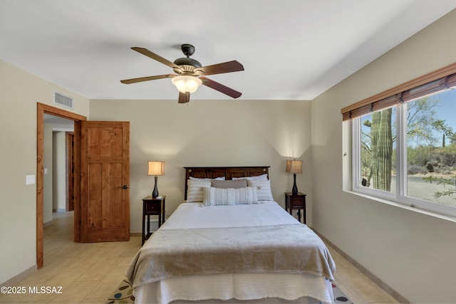 bedroom with visible vents, baseboards, ceiling fan, and light tile patterned floors