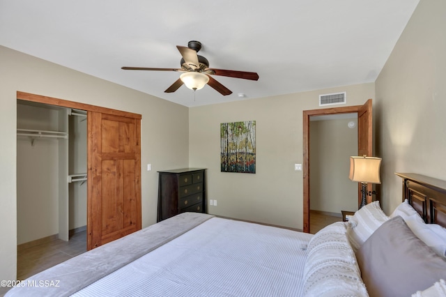 bedroom featuring light tile patterned flooring, a ceiling fan, baseboards, visible vents, and a closet