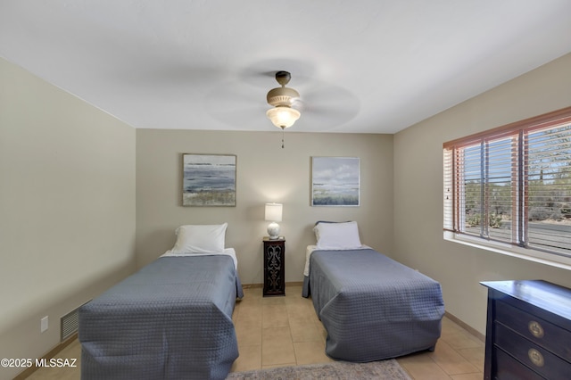 bedroom with light tile patterned flooring, a ceiling fan, visible vents, and baseboards